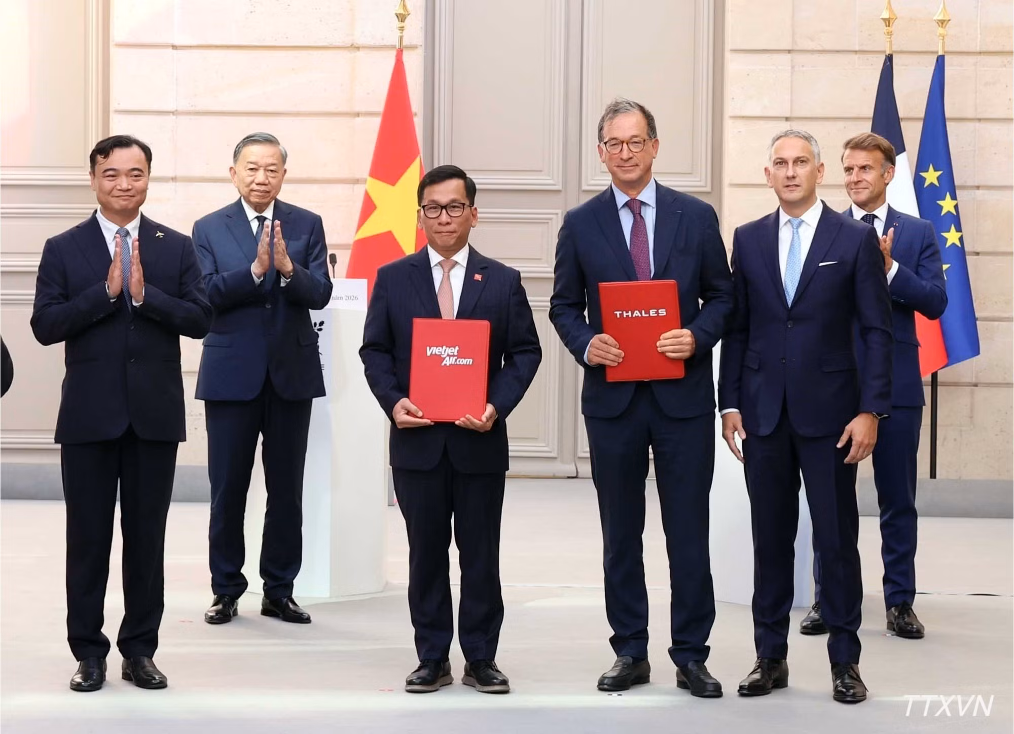 To Lam y Emmanuel Macron presencian el intercambio de firmas de documentos y acuerdos de cooperación entre Vietnam y Francia. (Foto: Thong Nhat/VNA)