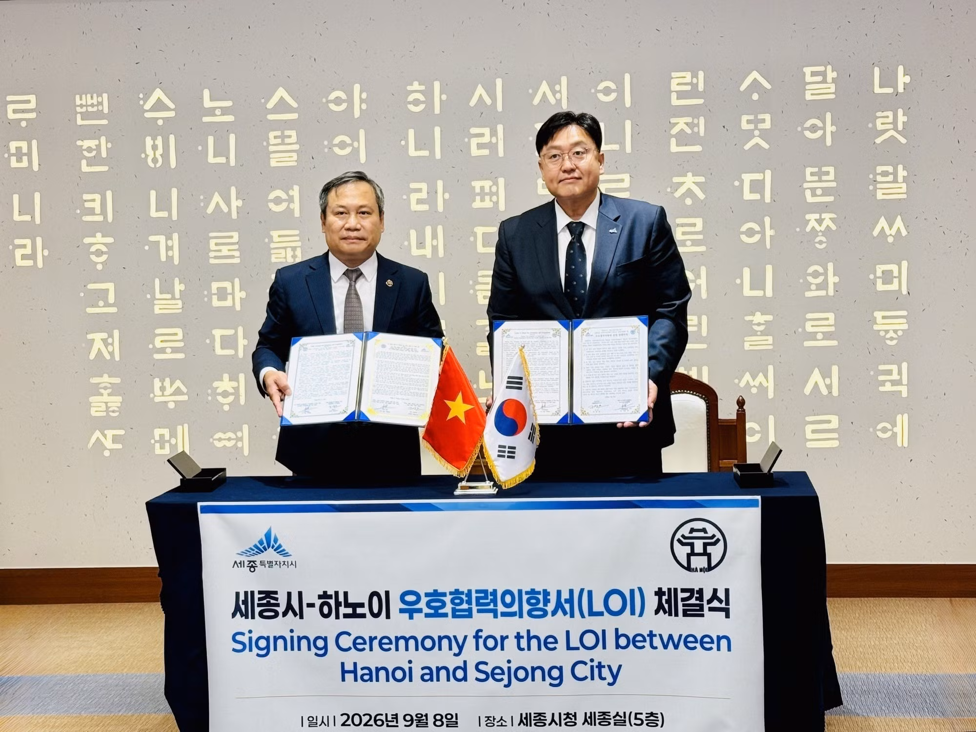 El presidente del Comité Popular de Hanói, Vu Dai Thang, y el alcalde de la ciudad de Sejong, Jo Sang-ho, firman la carta de intenciones de amistad y cooperación entre las dos ciudades. (Foto: VNA)