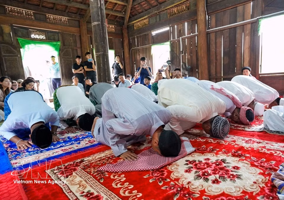 Hombres musulmanes Cham, vestidos con trajes tradicionales, acuden juntos a la mezquita para realizar las oraciones rituales. (Foto: VNA)