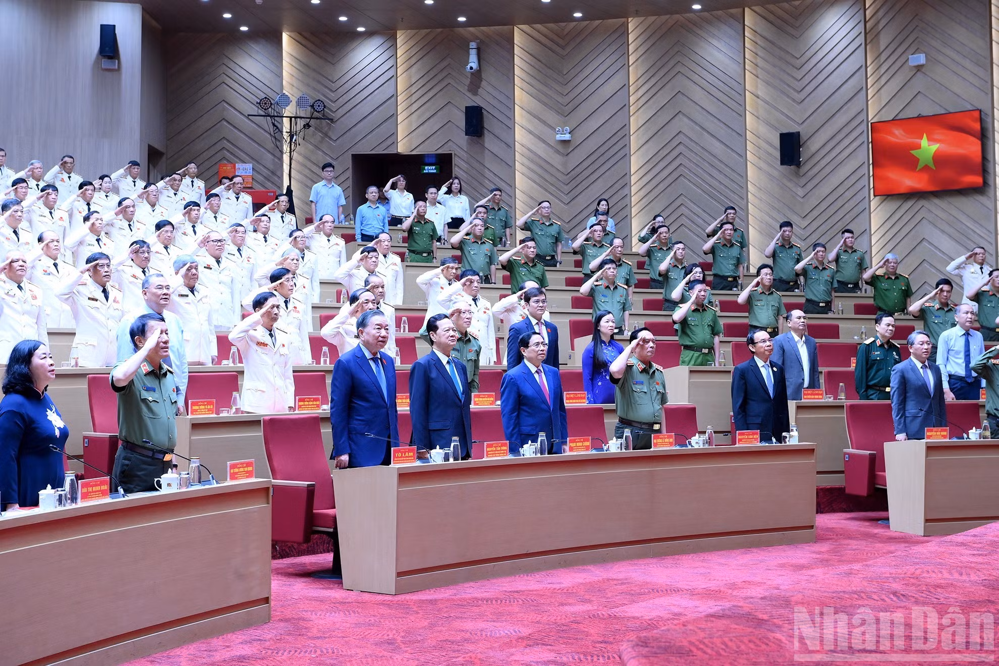 To Lam, dirigentes y exlíderes del Partido y el Estado y delegados realizan la ceremonia de saludo a la bandera nacional.