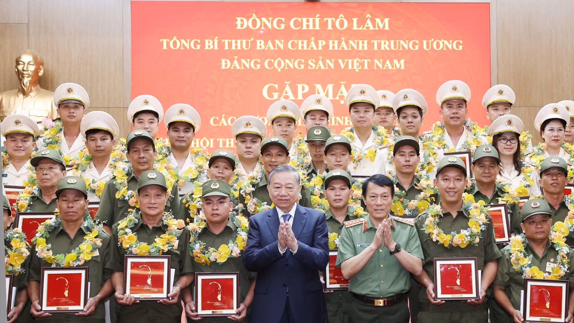 El secretario general del PCV, To Lam, junto a los miembros ejemplares de las fuerzas de seguridad pública y de protección del orden en la base. (Foto: Thong Nhat/VNA).