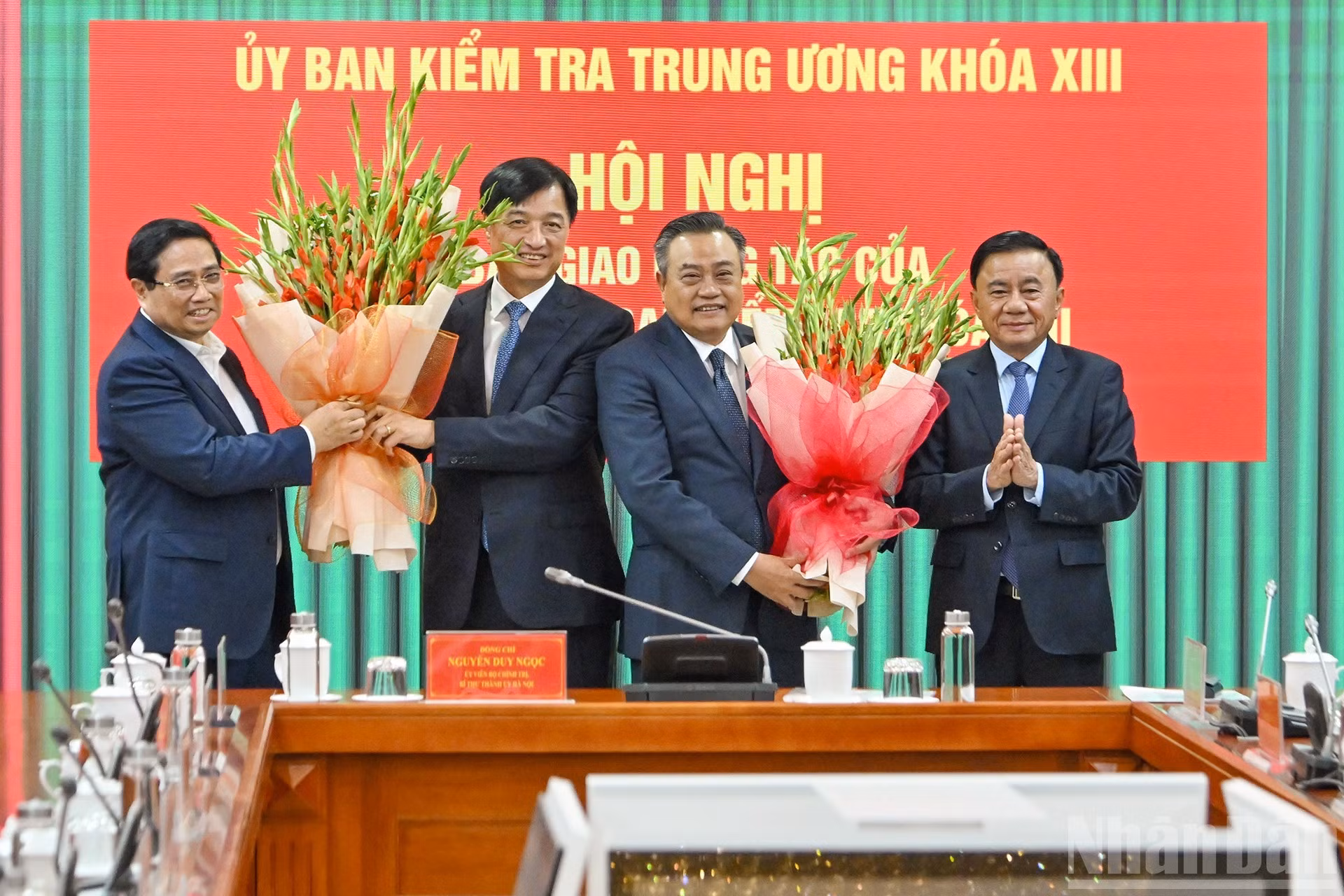 El primer ministro Pham Minh Chinh y el permanente del Secretariado del PCV, Tran Cam Tu, entregan flores para felicitar al secretario del Comité del Partido de Hanói, Nguyen Duy Ngoc, y al jefe de la Comisión de Control Disciplinario del Comité Central del PCV, Tran Sy Thanh.