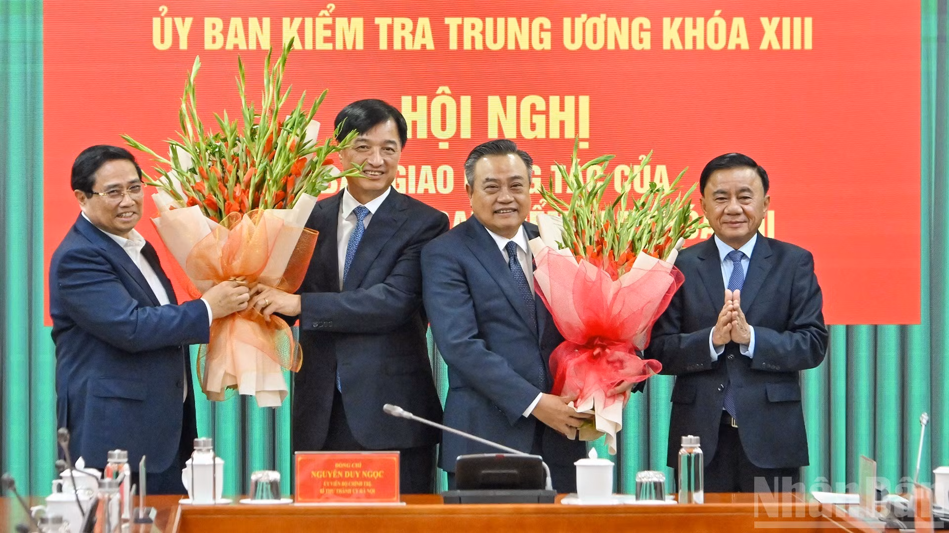 El primer ministro Pham Minh Chinh y el permanente del Secretariado del PCV, Tran Cam Tu, entregan flores para felicitar al secretario del Comité del Partido de Hanói, Nguyen Duy Ngoc, y al jefe de la Comisión de Control Disciplinario del Comité Central del PCV, Tran Sy Thanh.