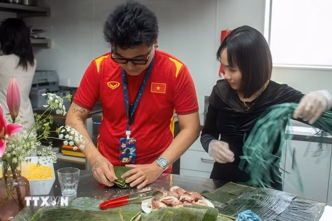 Los participantes elaboran Banh Chung (paste de arroz glutinoso). (Fuente: VNA)