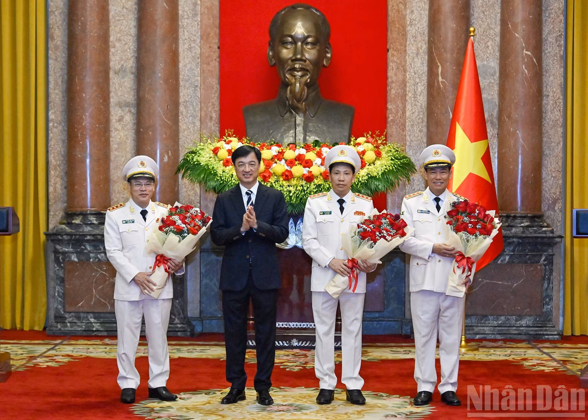 El jefe de la Comisión de Control Disciplinario del Comité Central del Partido, Nguyen Duy Ngoc, les hace entrega de flores para felicitar a Le Tan Toi, Le Van Tuyen y Nguyen Van Long.