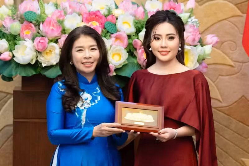 Una representante de la Oficina de la Asamblea Nacional entrega obsequios a Phan Thi Kim Oanh, presidenta de Miss Multicultural World 2026.