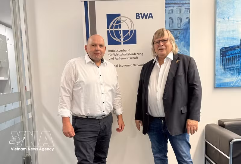 Heinrich Gerd-Witte (camisa blanca, izquierda), miembro del Consejo Asesor y presidente del Comité de Agricultura y Alimentación de la Asociación Alemana para el Desarrollo Económico y el Comercio Exterior (BWA), y Hans-Joachim Radtke, representante comercial de la BWA para Vietnam y presidente del Foro Económico y de Innovación Alemania-Vietnam. (Foto: VNA)