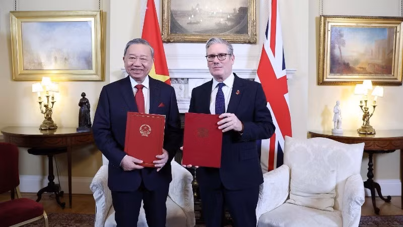 El secretario general del Partido Comunista de Vietnam, To Lam, y el primer ministro del Reino Unido, Keir Starmer, intercambian una declaración conjunta sobre la elevación de los nexos bilaterales a una Asociación Estratégica Integral. (Foto: VNA) 