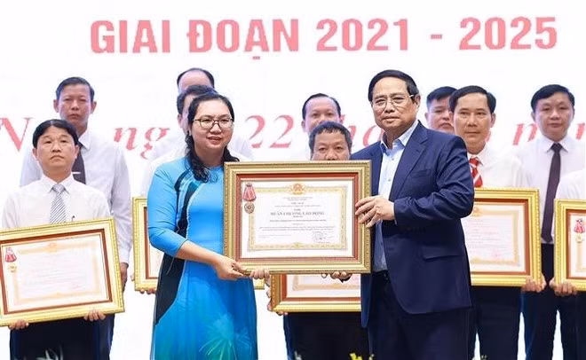 El primer ministro Pham Minh Chinh otorga la Orden de Trabajo de Tercera Clase a las organizaciones por sus destacados logros en el movimiento de emulación "Todo el país se une para construir nuevas zonas rurales". (Foto: VNA)