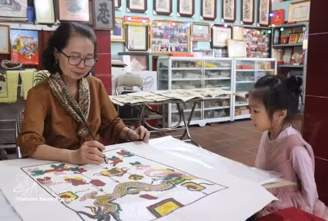 La maestra Nguyen Thi Oanh preserva las pinturas de Dong Ho mediante la enseñanza a la generación juvenil. (Foto: VNA)
