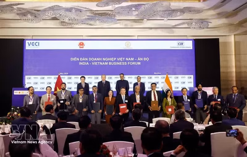 El secretario general del Partido Comunista y presidente de Vietnam, To Lam (izquierda, segundo, fila de atrás), y el ministro principal de Maharashtra, Devendra Fadnavis (izquierda, tercero, fila de atrás), presencian el intercambio de acuerdos de cooperación entre empresas vietnamitas e indias en el Foro Empresarial India-Vietnam celebrado en Mumbai, estado de Maharashtra, India, el 7 de mayo. (Foto: VNA)
