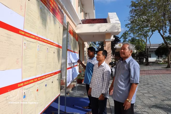 Pobladores consultan la lista oficial de candidatos a diputados a la Asamblea Nacional y a los Consejos Populares, expuesta públicamente en la sede del Comité Popular de la comuna de Song Loc. (Foto: VNA)