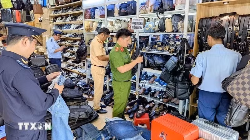 Las autoridades inspeccionan y confiscan una gran cantidad de productos de origen desconocido en una tienda (Foto: VNA)