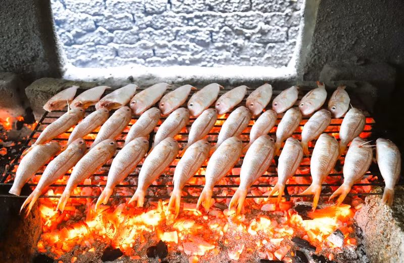 El pescado “Luong” (jurel o pez escádido) se coloca sobre parrillas hechas con pequeñas varillas de hierro soldadas y se asa directamente sobre el fuego de carbón vegetal.