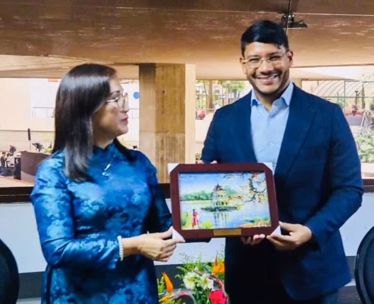 Dinh Thi Mai, subjefa de la Comisión de Propaganda y Movilización de Masas del Comité Central del PCV, entrega un regalo a Rander Peña, vicepresidente encargado de Asuntos Internacionales del PSUV. (Foto: Embajada de Vietnam en Venezuela)