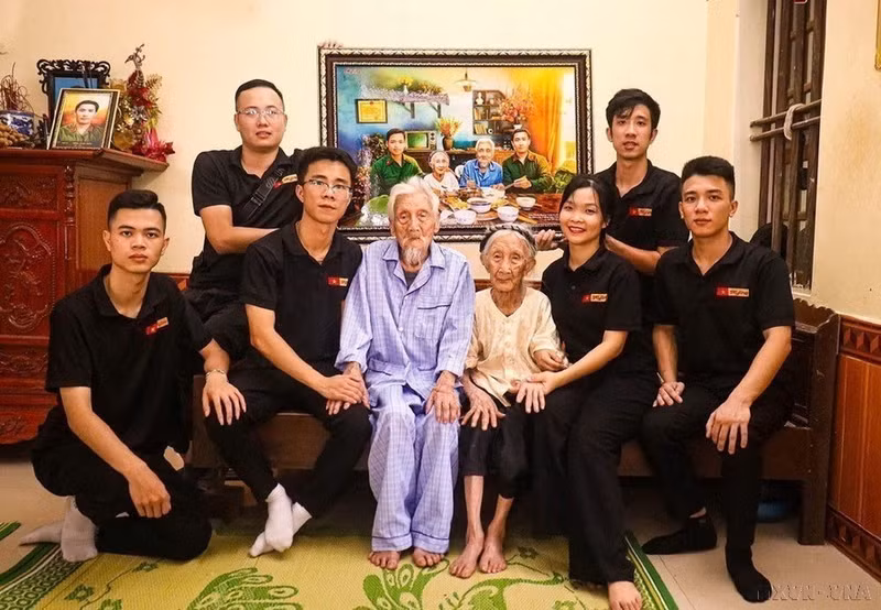 El grupo de restauración de imágenes Skyline entrega a la Madre Heroína de Vietnam Nguyen Thi Ngach una fotografía que simula una comida familiar con sus dos hijos.