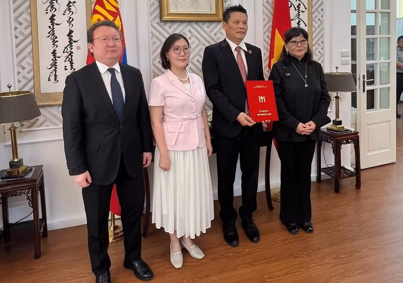 La embajadora de Mongolia, Ganbaatar Hulan, y representantes de la Universidad de Cultura y Arte de Mongolia entregan el título de 'Profesor Honorario' al director Le Quy Duong. (Foto: Nhan Dan)