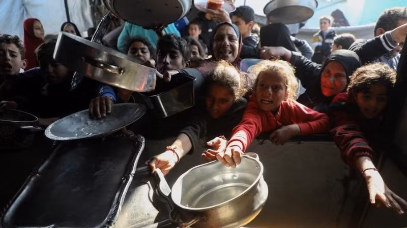 Ciudadanos palestinos reciben alimentos gratuitos en un campo de refugiados en Beit Lahia, al norte de la Franja de Gaza, en una foto tomada el 15 de marzo de 2026. (Foto: XINHUA)