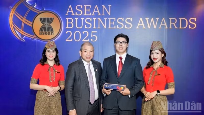 Teo Siong Seng, presidente del Consejo Asesor Empresarial de la Asean en Singapur (segundo a la izquierda), entrega el premio al representante de Vietjet. (Foto: Nhan Dan)