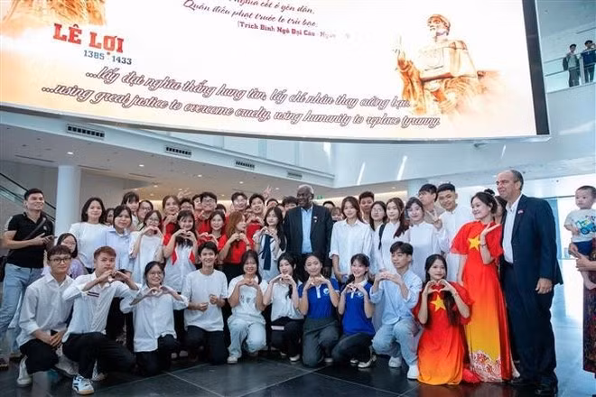 El presidente de la Asamblea Nacional del Poder Popular y del Consejo de Estado de Cuba, Esteban Lazo Hernández, se toma una foto con jóvenes y visitantes del Museo de Historia Militar de Vietnam. (Foto: VNA)