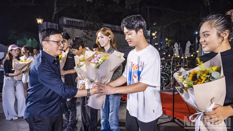 El periodista Le Quoc Minh, miembro del Comité Central del Partido Comunista de Vietnam (PCV), presidente editor de Nhan Dan, subjefe de la Comisión de Propaganda y Educación del Comité Central del PCV y titular de la Asociación de Periodistas del país, entrega flores a los cantantes. (Foto: Nhan Dan)