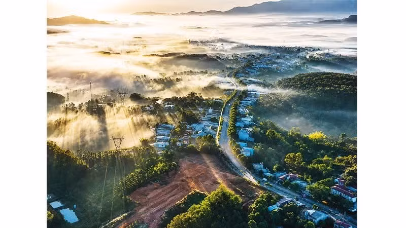 Los primeros rayos del sol atraviesan la niebla, creando un paisaje sereno y majestuoso.